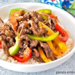 pepper steak over rice in a white bowl