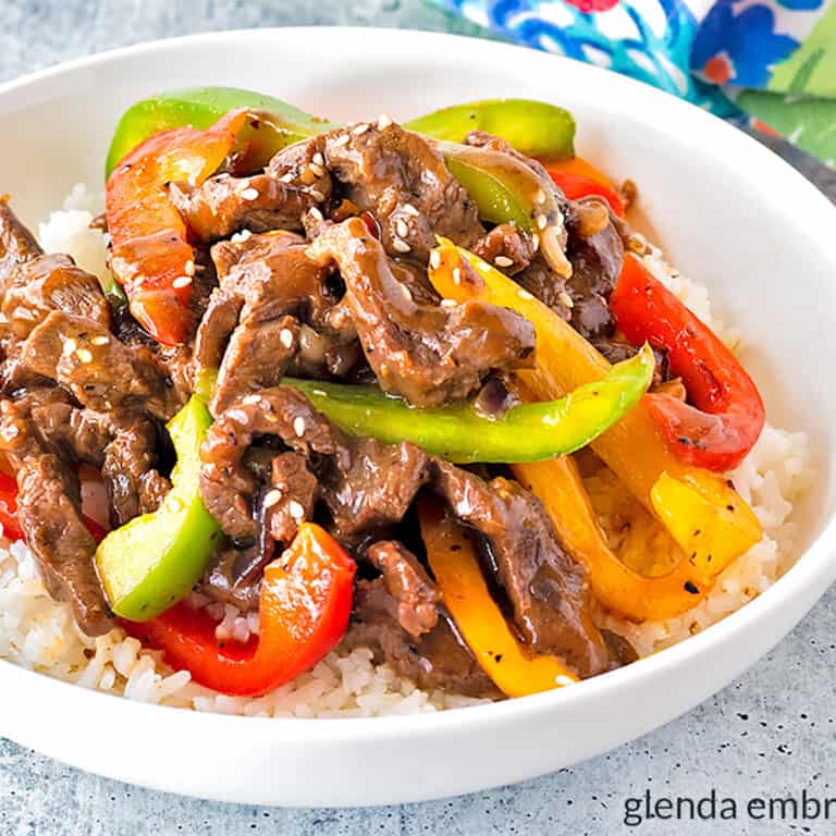pepper steak over rice in a white bowl