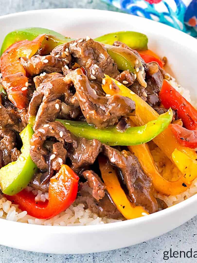 pepper steak over rice in a white bowl