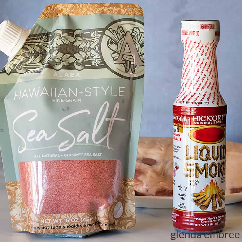 a bag of red Hawaiian sea salt next to a bottle of liquid smoke