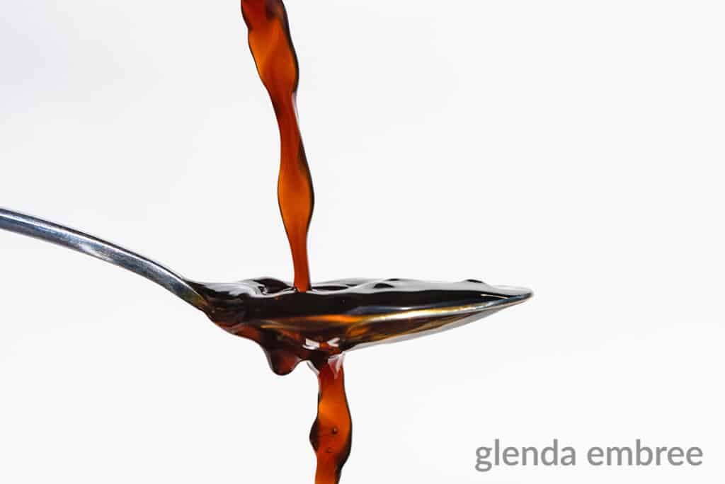 soy sauce being poured into a spoon