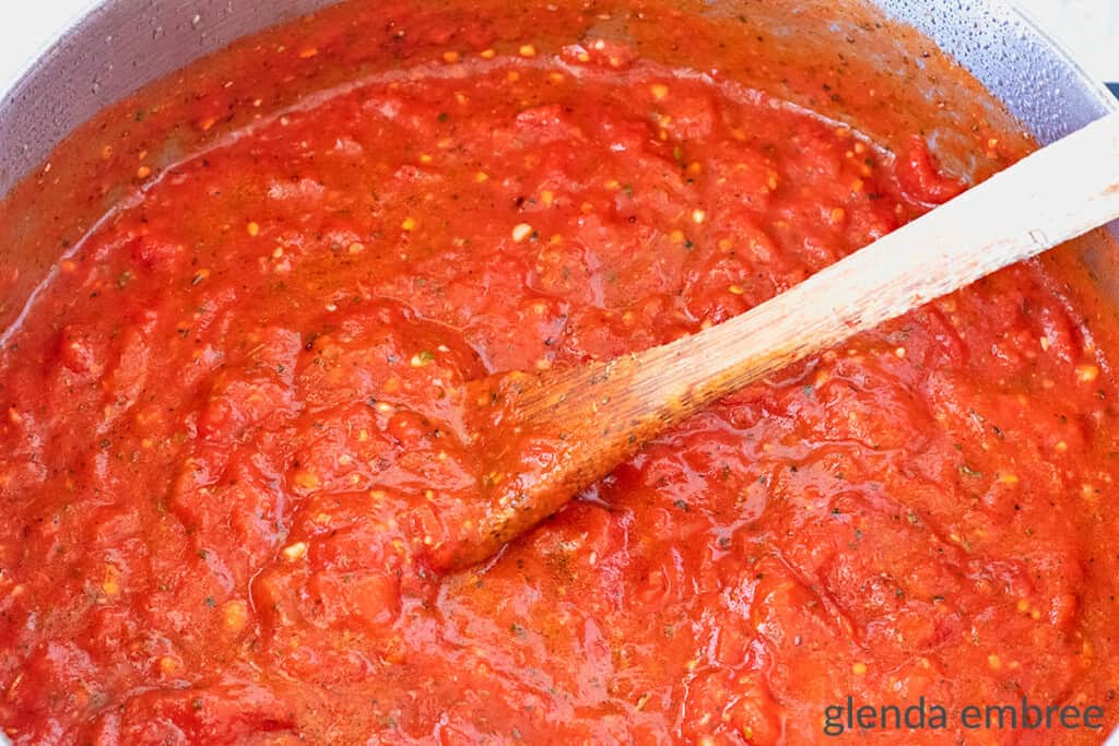 homemade marinara in pan with wooden spoon