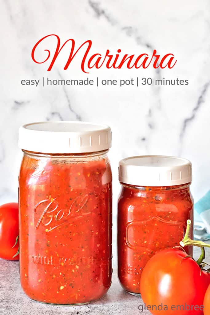 homemade marinara recipe in jars on concrete counter top with fresh tomatoes and a blue and white gingham napkin