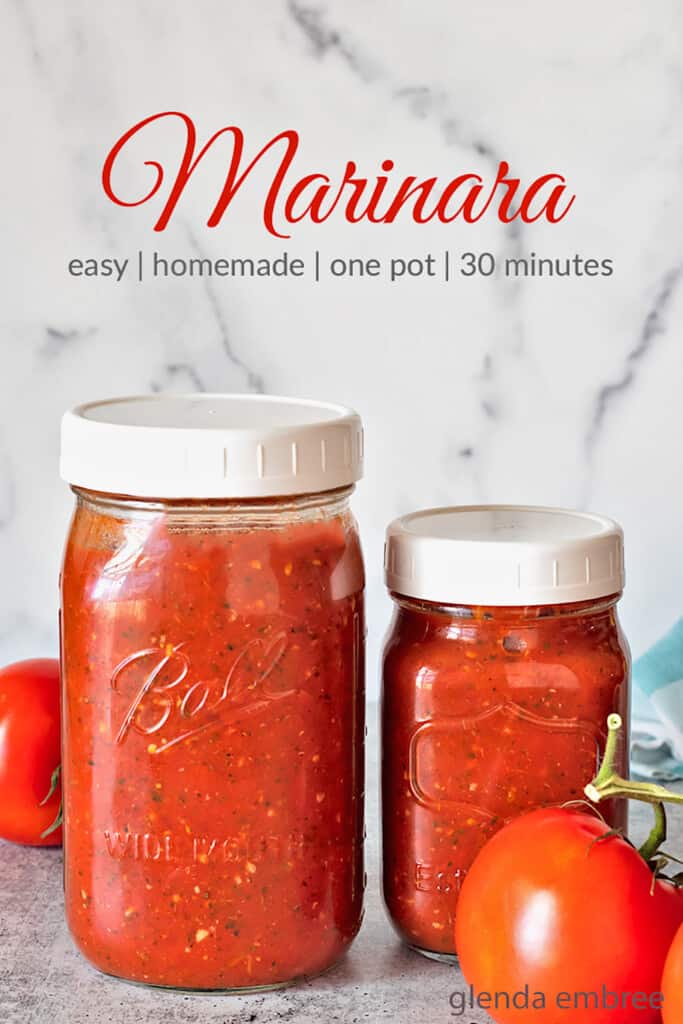 homemade marinara recipe in jars on concrete counter top with fresh tomatoes and a blue and white gingham napkin