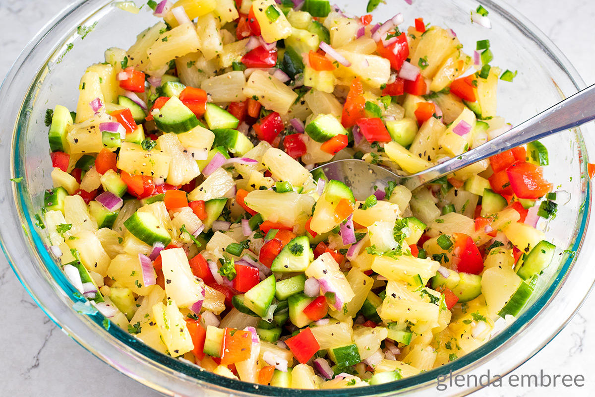 pineapple salsa in a glass mixing bowl ready to top pineapple chicken rice bowls