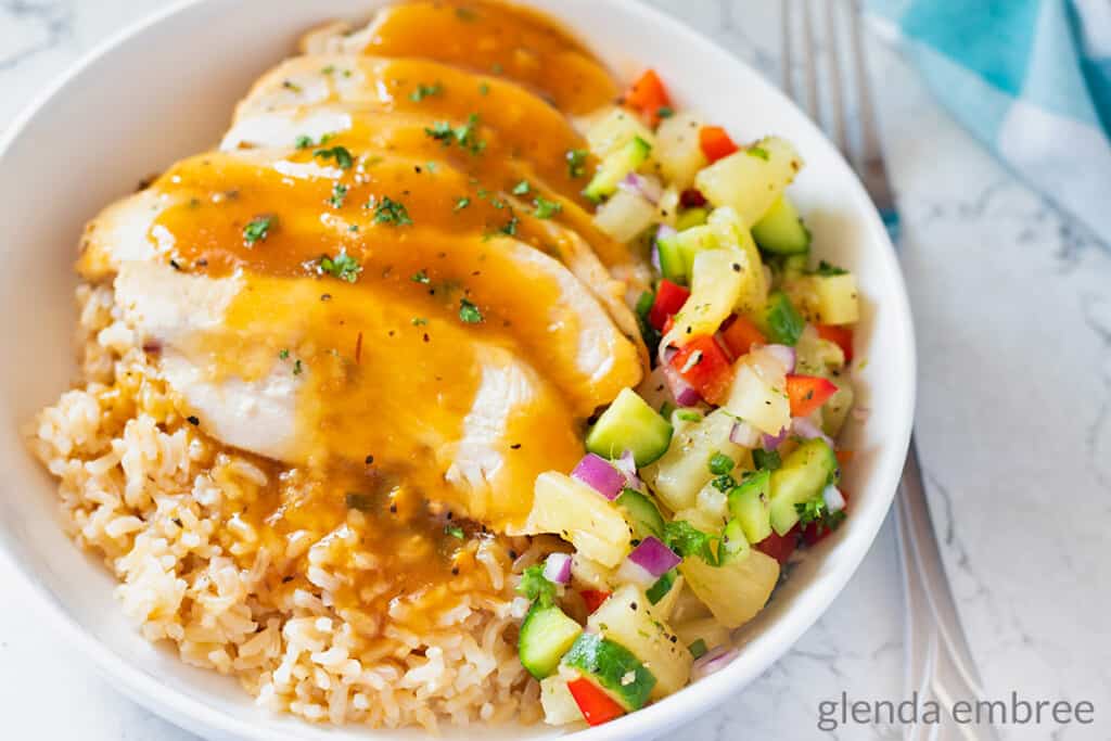 Pineapple Chicken Rice Bowl with Pineapple Salsa in a white ceramic bowl.  Pineapple Chicken is a great intentional leftover.