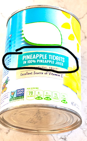 canned pineapple in the can - 100% pineapple juice is circled