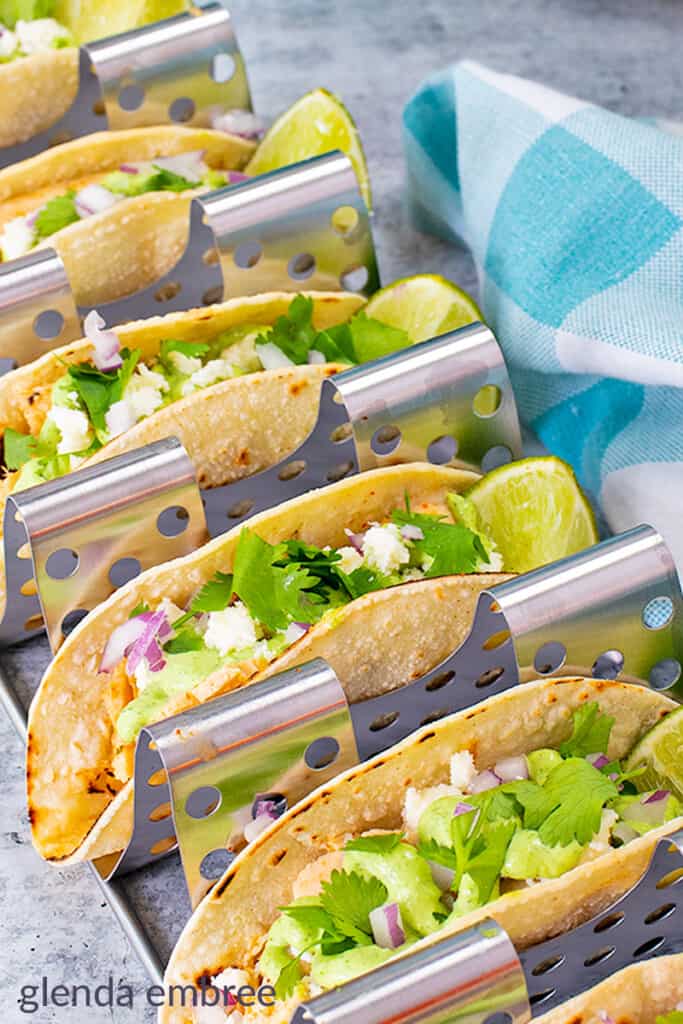 chicken street tacos made with chicken leftovers. Tacos are in a metal taco rack that holds six at one time.