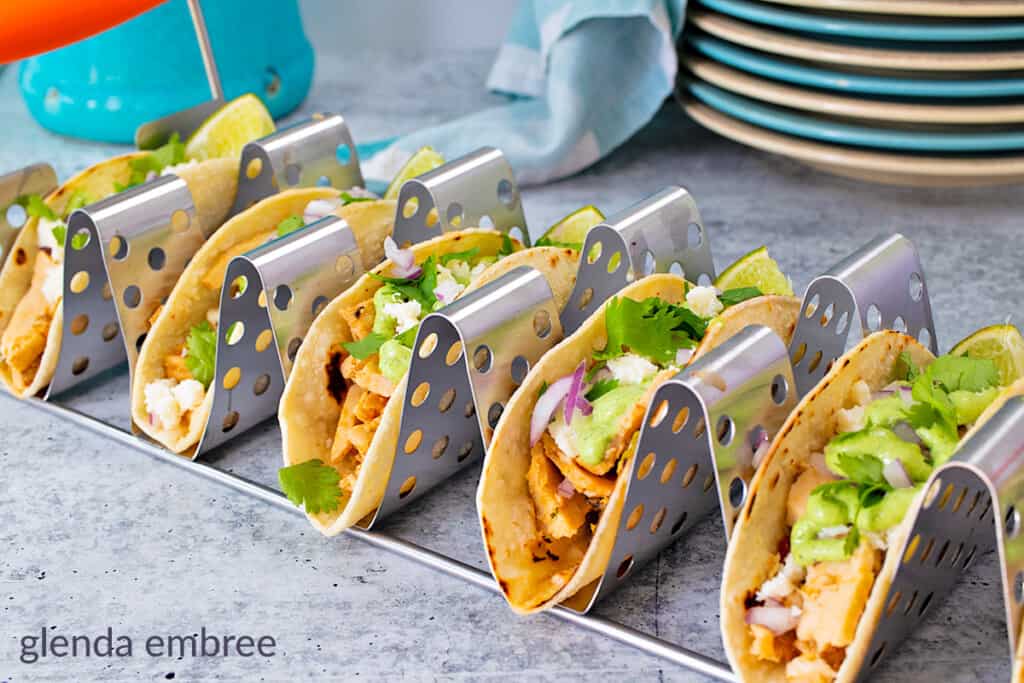 chicken street tacos made with chicken leftovers.  Tacos are in a metal taco rack that holds six at one time.