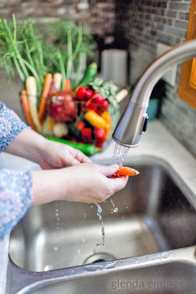 glenda embree washing vegetables at the kitchen sink