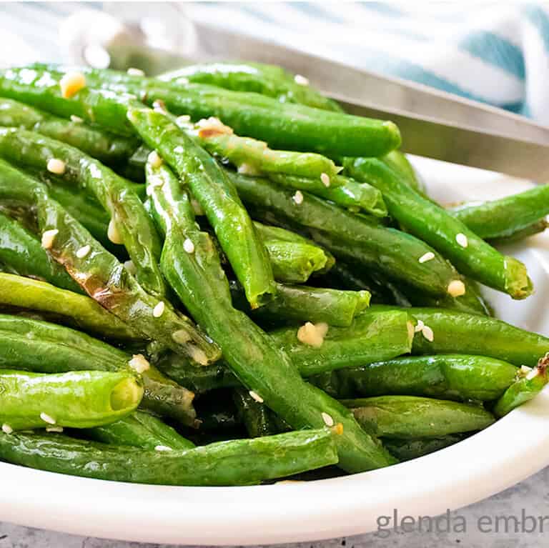 Air Fryer Green Beans with Garlic Butter Sauce in a white bowl.