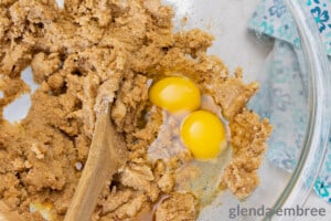 adding eggs and vanilla to cookie dough