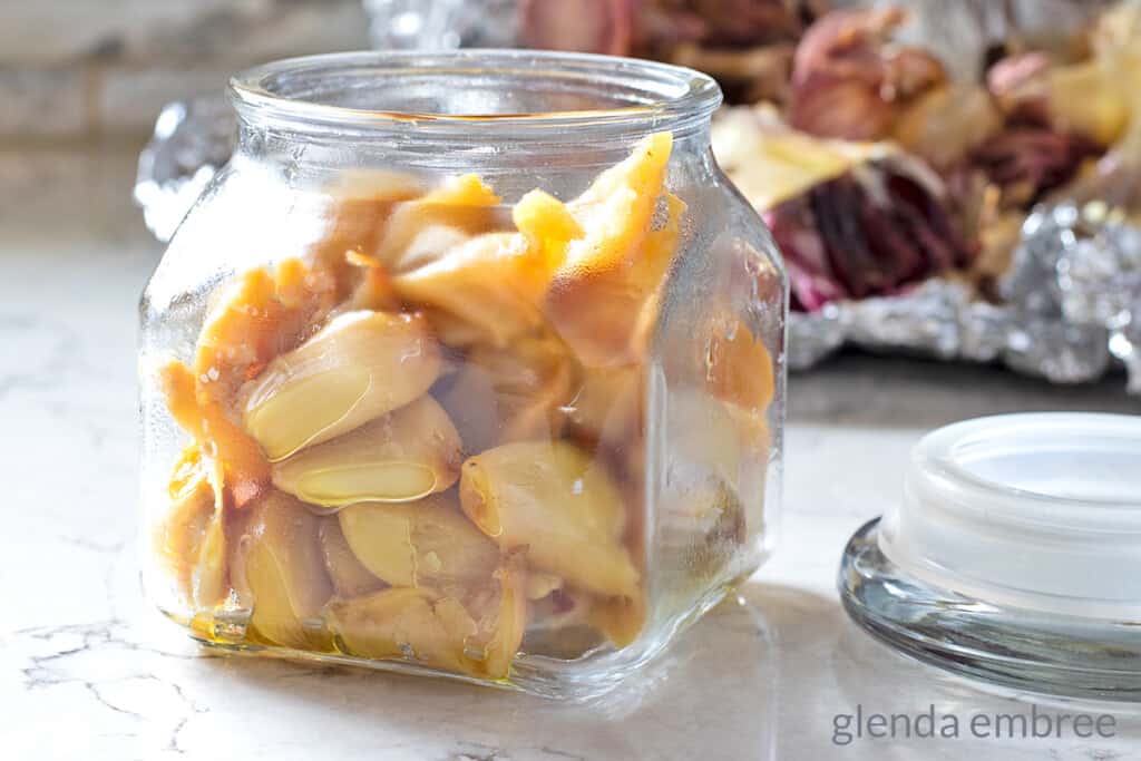 roasted garlic cloves in a jar with no oil on them