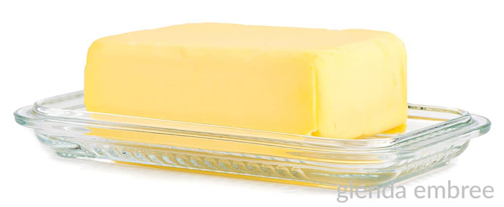 stick of butter on a clear glass plate