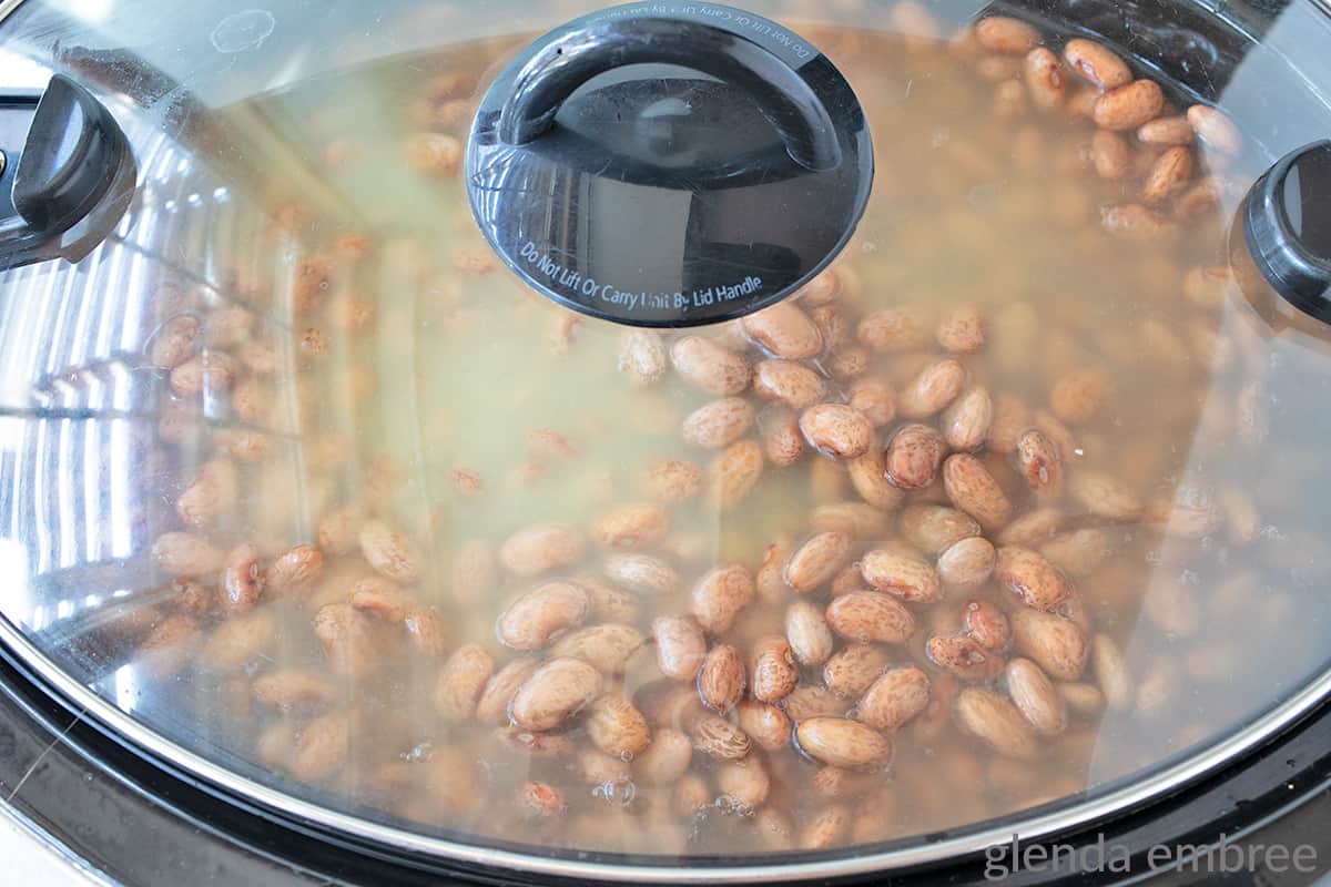 looking at pinto beans and broth through the lid of a slow cooker