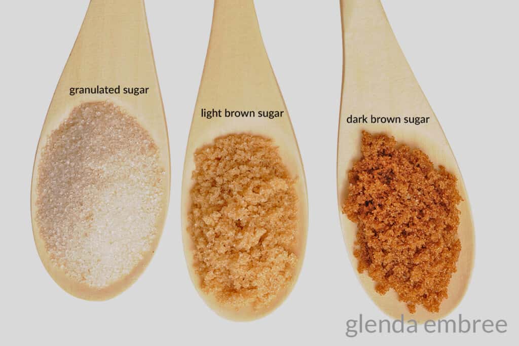 3 wooden spoons - one with granulated sugar, one iwth light brown sugar and one with dark brown sugar