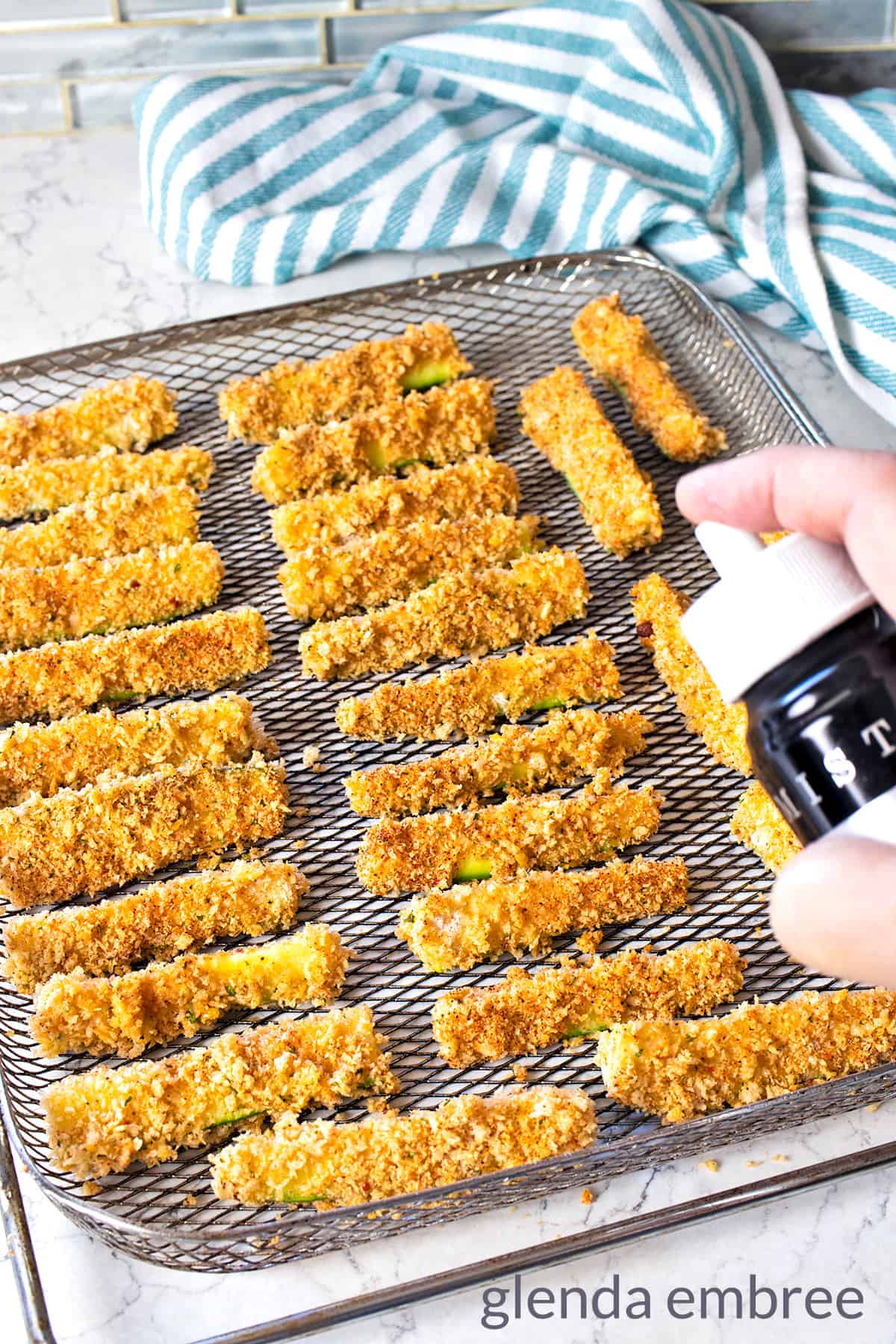 misting prepped zucchini fries with oil before air frying
