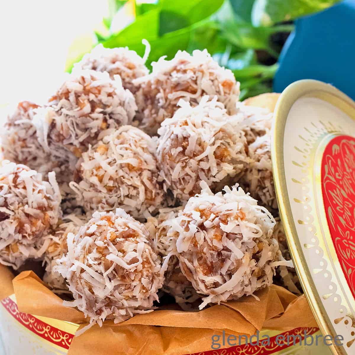 Date Balls in a vintage cookie tin on a concrete countertop