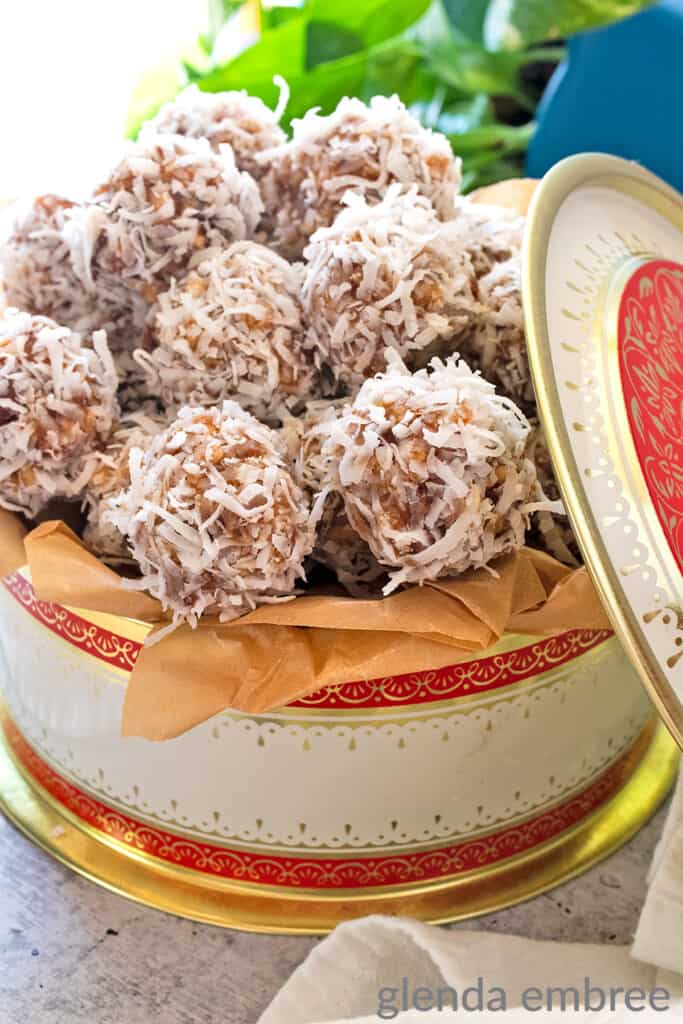 Date Balls in a vintage cookie tin on a concrete countertop