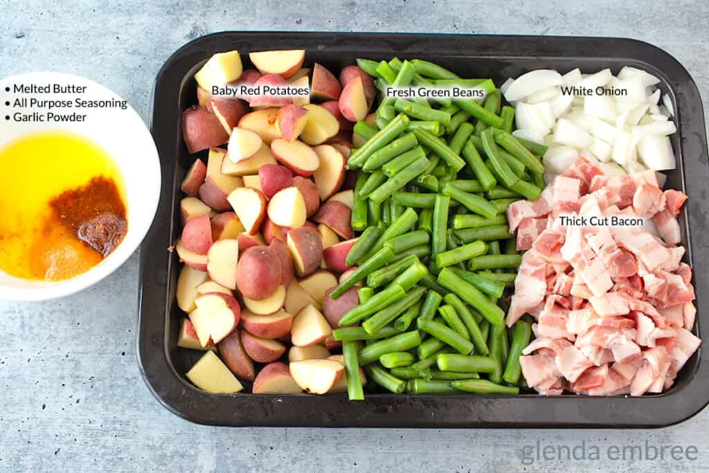 Green Beans and Potatoes Ingredients on a broiler pan baby red potatoes, fresh green beans, chopped onion, diced bacon.