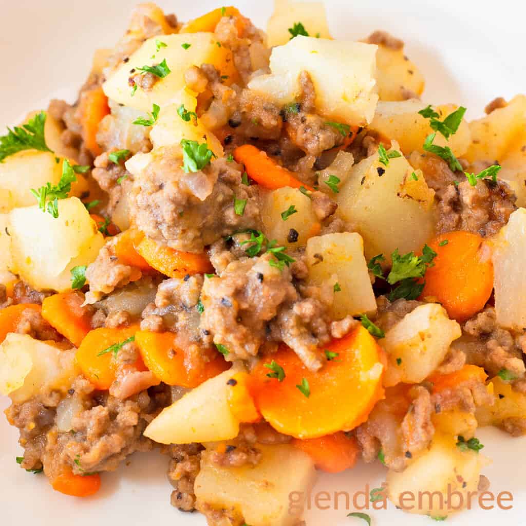Ground Beef and Potatoes Casserole in a shallow white bowl on a concrete counter