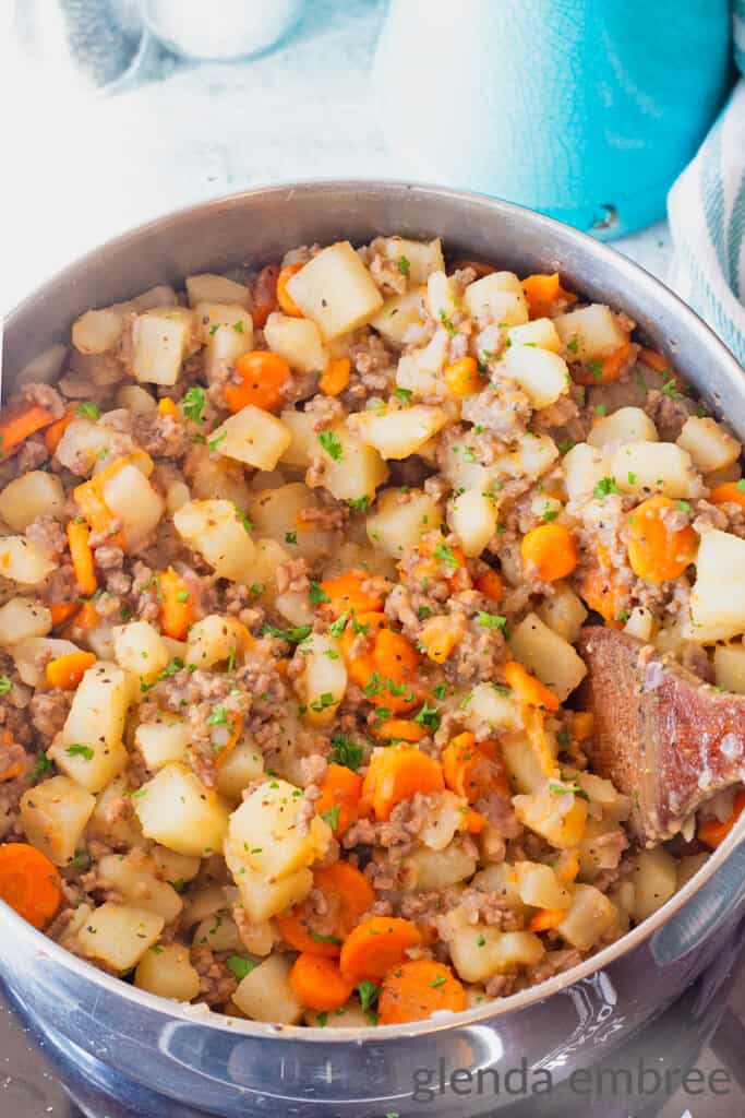 Ground Beef and Potatoes Casserole in a stainless steel pot on the stove.   Easy Potato and Ground beef recipe  for 30 minute meal prep.