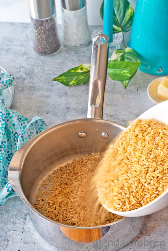 adding rice to a saucepan