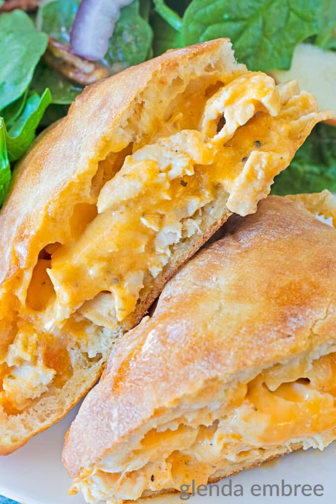 Buffalo Ranch Chicken Melts on a white plate with spinach salad.
