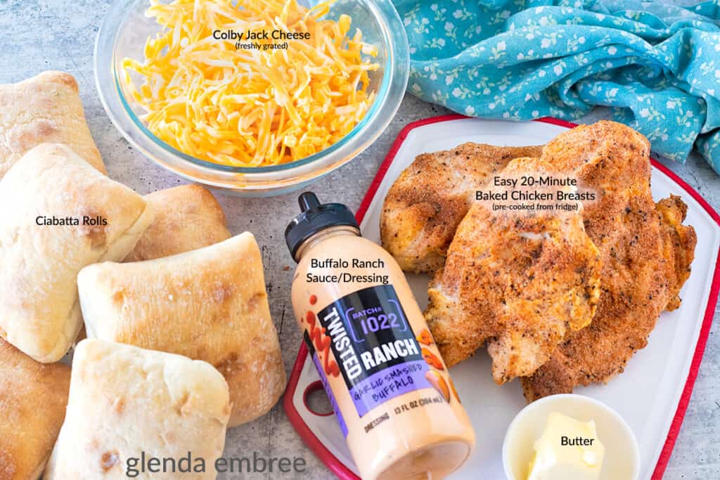 Ingredients to Make Buffalo Ranch Chciken Melts: pre-cooked chicken breasts, butter, buffalo ranch sauce, grated Colby Jack Chees and Ciabatta Rolls