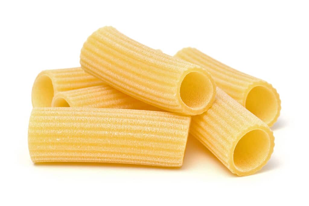 dry rigatoni pasta in a pile on a white counter