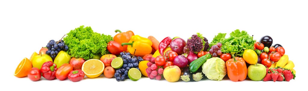 garden fresh vegetables and fruit piled in the center of a white table