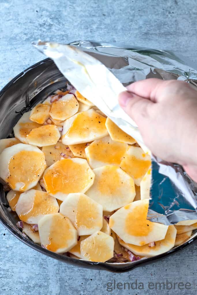 Placing foil over the final layer of prepped potato slices