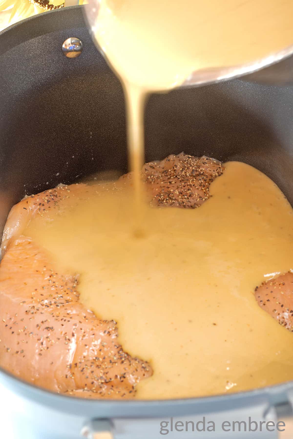 pouring homemade gravy over turkey tenderloins in a slow cooker