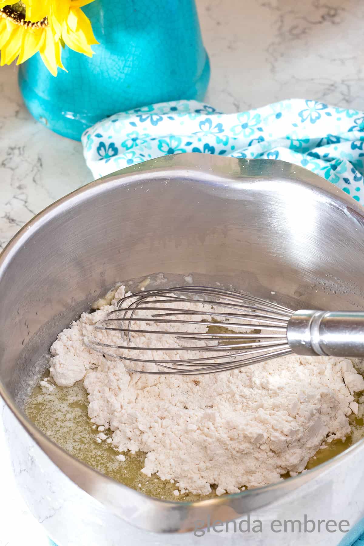 adding flour to melted butter in a sauce pan to make a roux