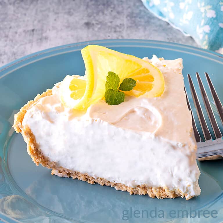 Cream cheese Lemonade Pie slice on a blue stoneware plate.
