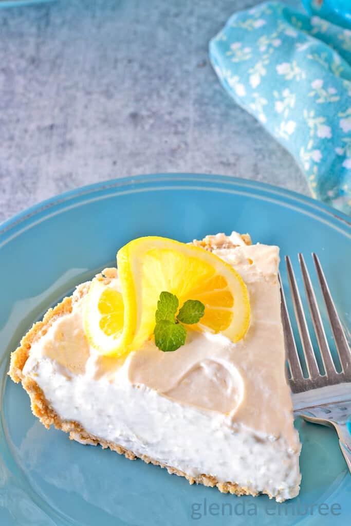 Cream cheese Lemonade Pie slice on a blue stoneware plate.