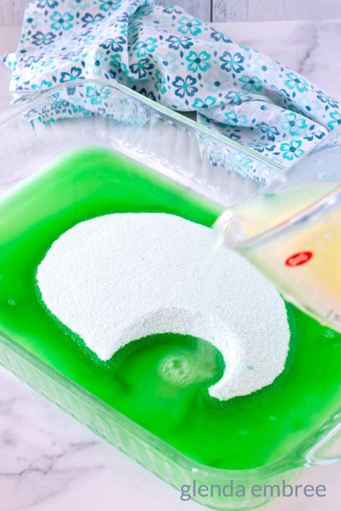 Lime gelatin powder being dissolved in fruit juice.