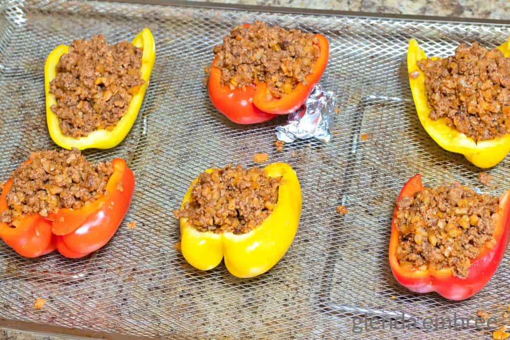 Stuffed Bell Peppers on an air fryer basket ready to be cooked.