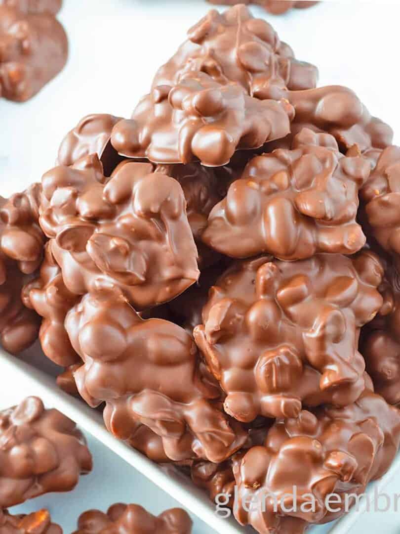Chocolate Peanut Clusters in a square ceramic bowl.