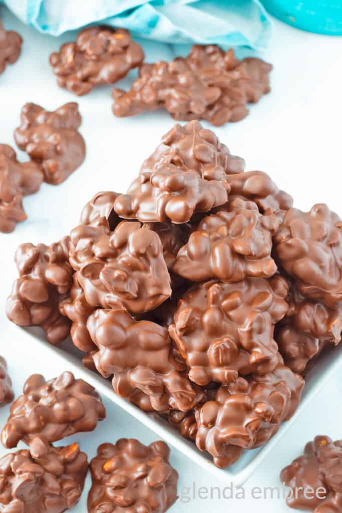 Chocolate Peanut Clusters in a square ceramic bowl.