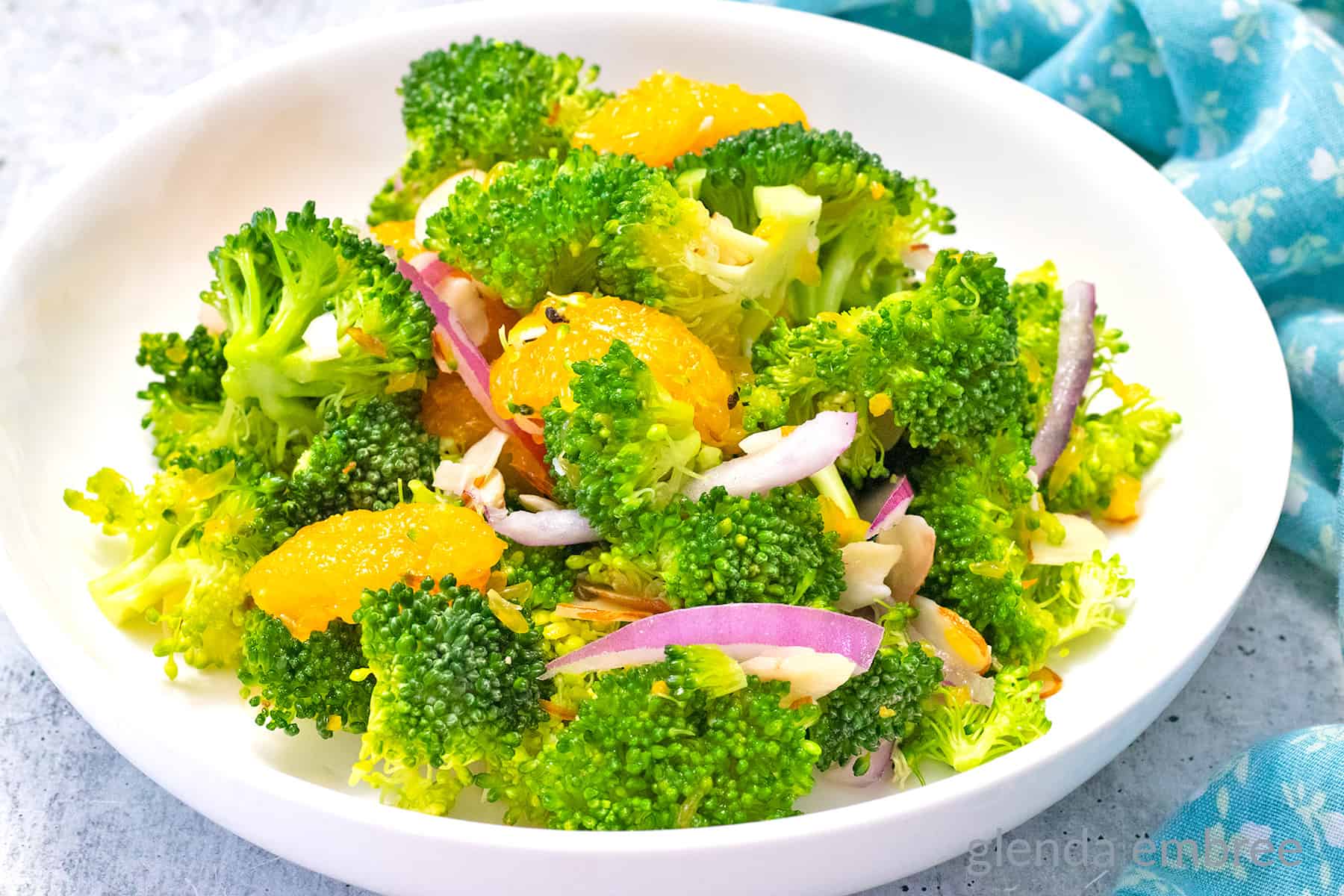 Crunchy Broccoli Salad with Mandarin Oranges on a white plate.  A quick and easy potluck recipe idea.