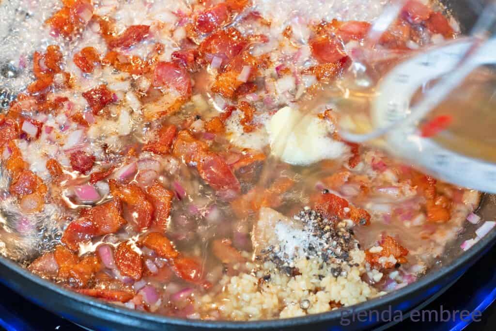 Adding chicken broth to the bacon and seasonings.