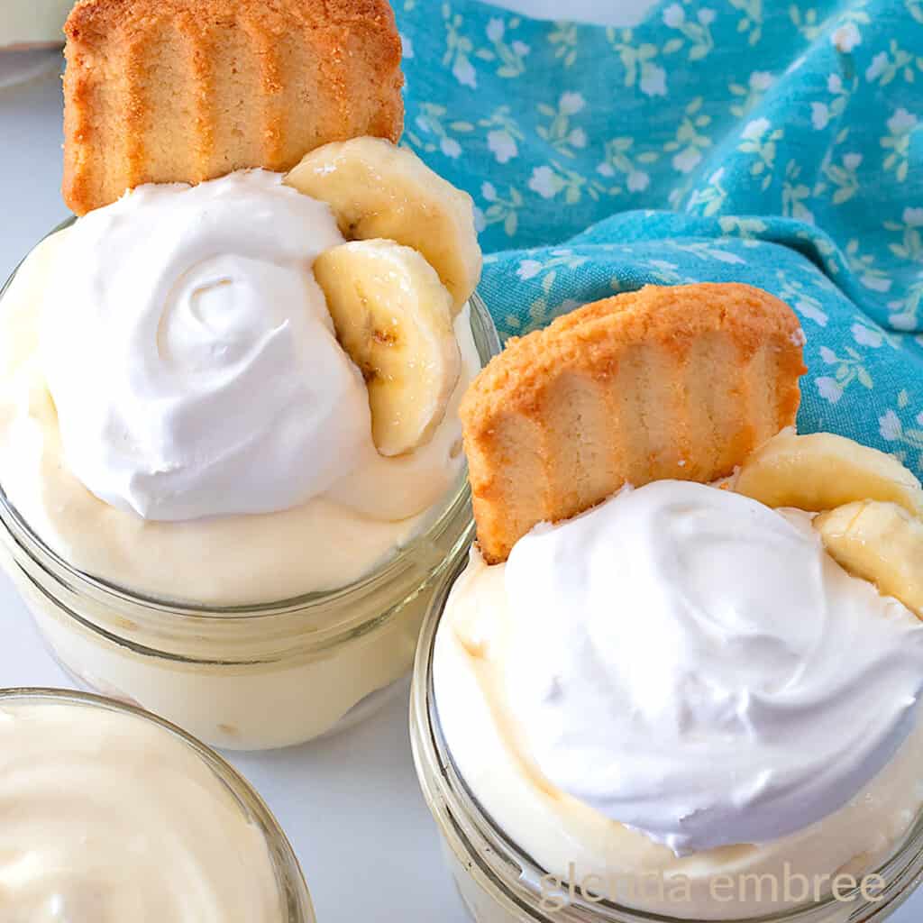 Banana Pudding Cups. Homemade banana pudding in individual serving size mason jars and topped with whipped cream, banana slices and a shortbread cookie.