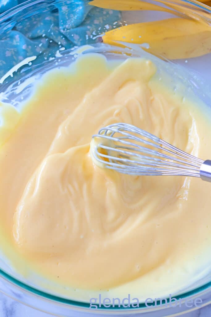 Whisking together instant banana pudding mix with milk and vanilla extract.