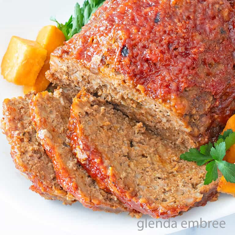 Stove Top Stuffing Meatloaf (Slow Cooker Meatloaf) served on a white platter with sweet potato chunks.