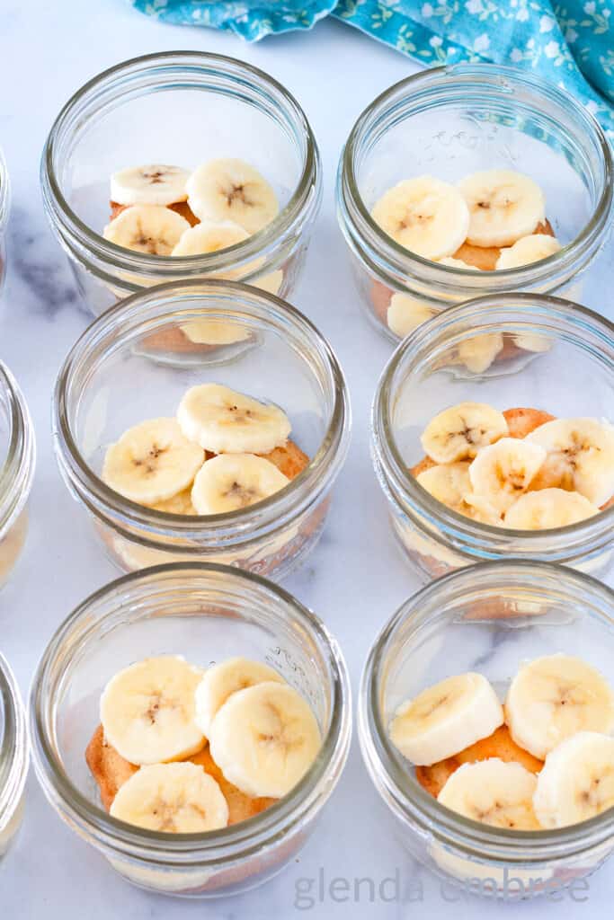 Banana Slices over a cookie in the bottom of a clear glass half-pint mason jar.