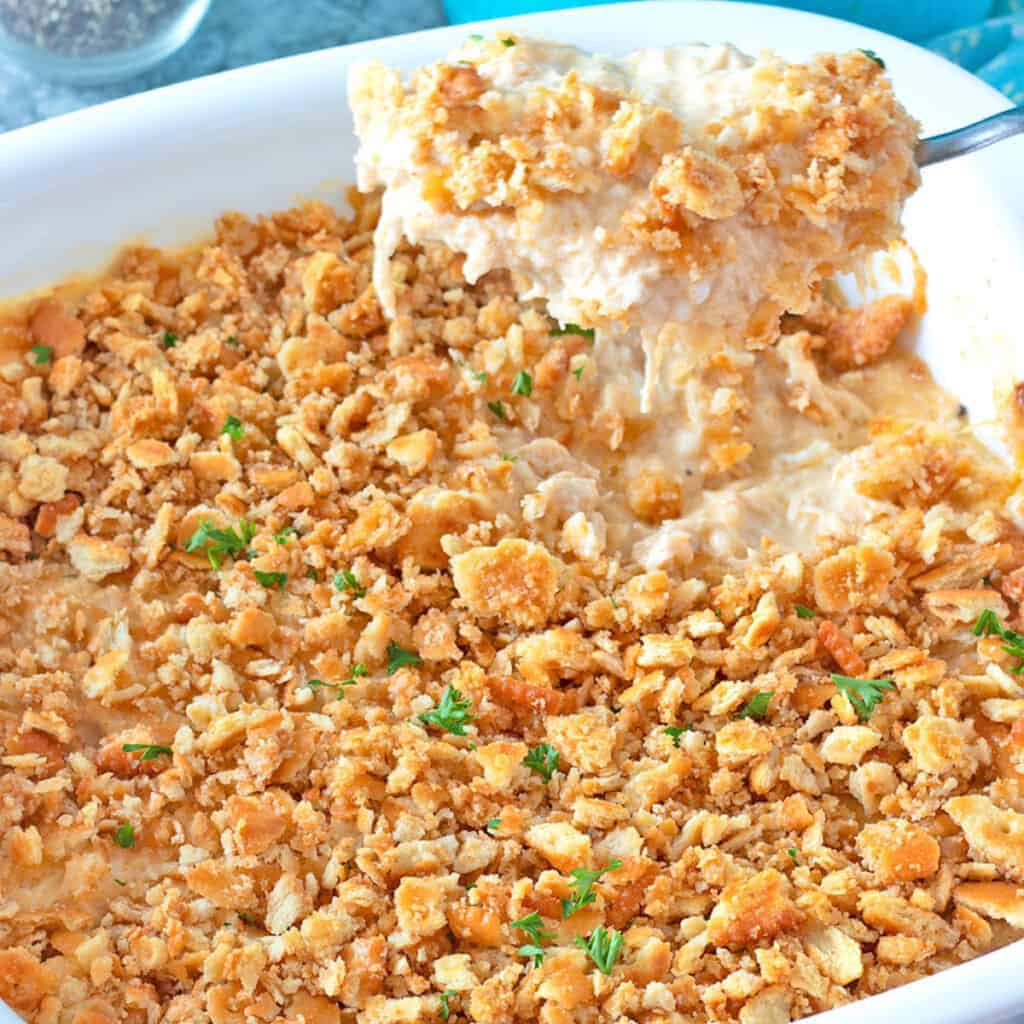 Millian Dolloar Chicken Casserole being served from a white ceramic baking dish.