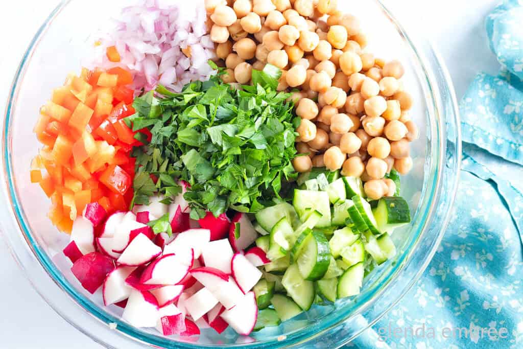 Chickpea Salad Ingredients in a clear glass bowl.