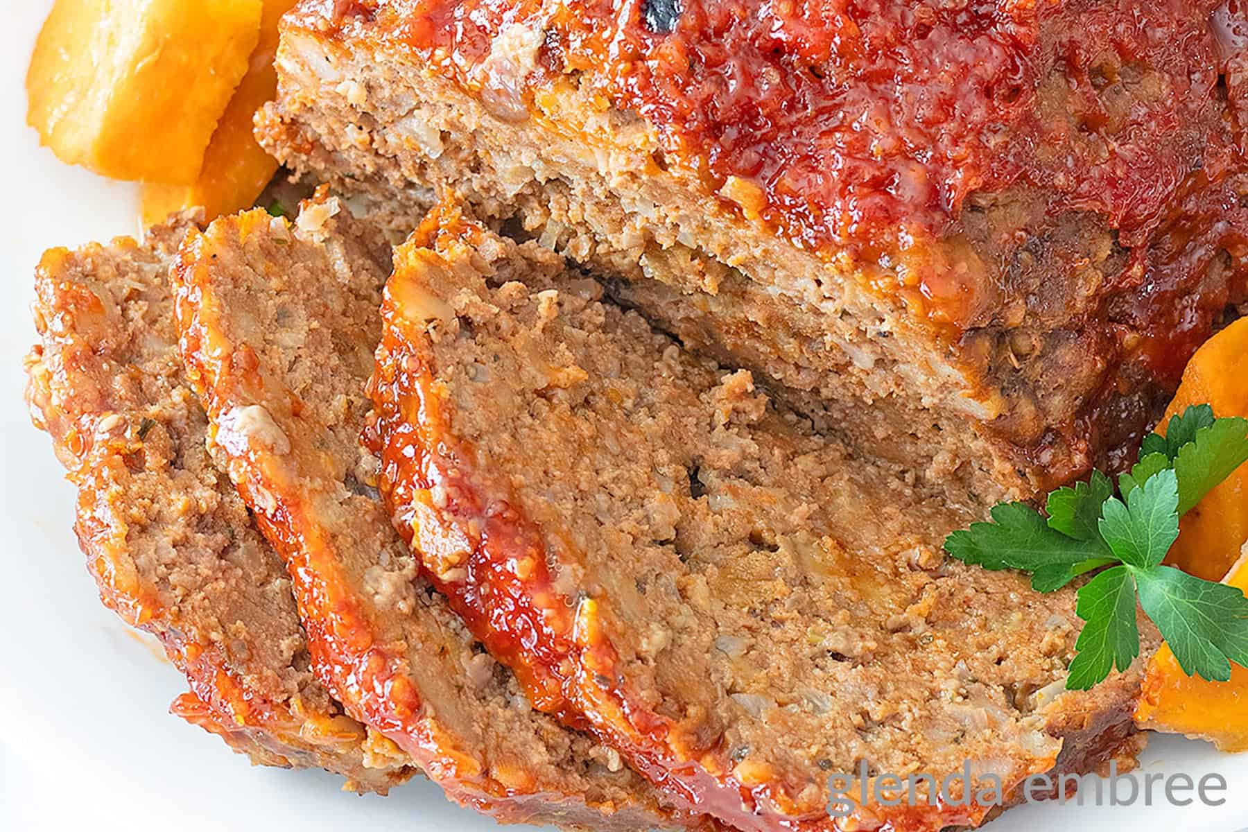 Stove Top Stuffing Meatloaf (Slow Cooker Meatloaf) served on a white platter with sweet potato chunks.