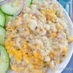 Creamy One Pan Chicken and Rice on a white plate with a cucumber salad.